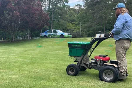 technician fertilizing lawn