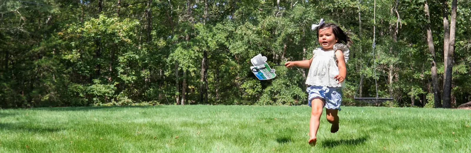 Girl running playing green lush grass